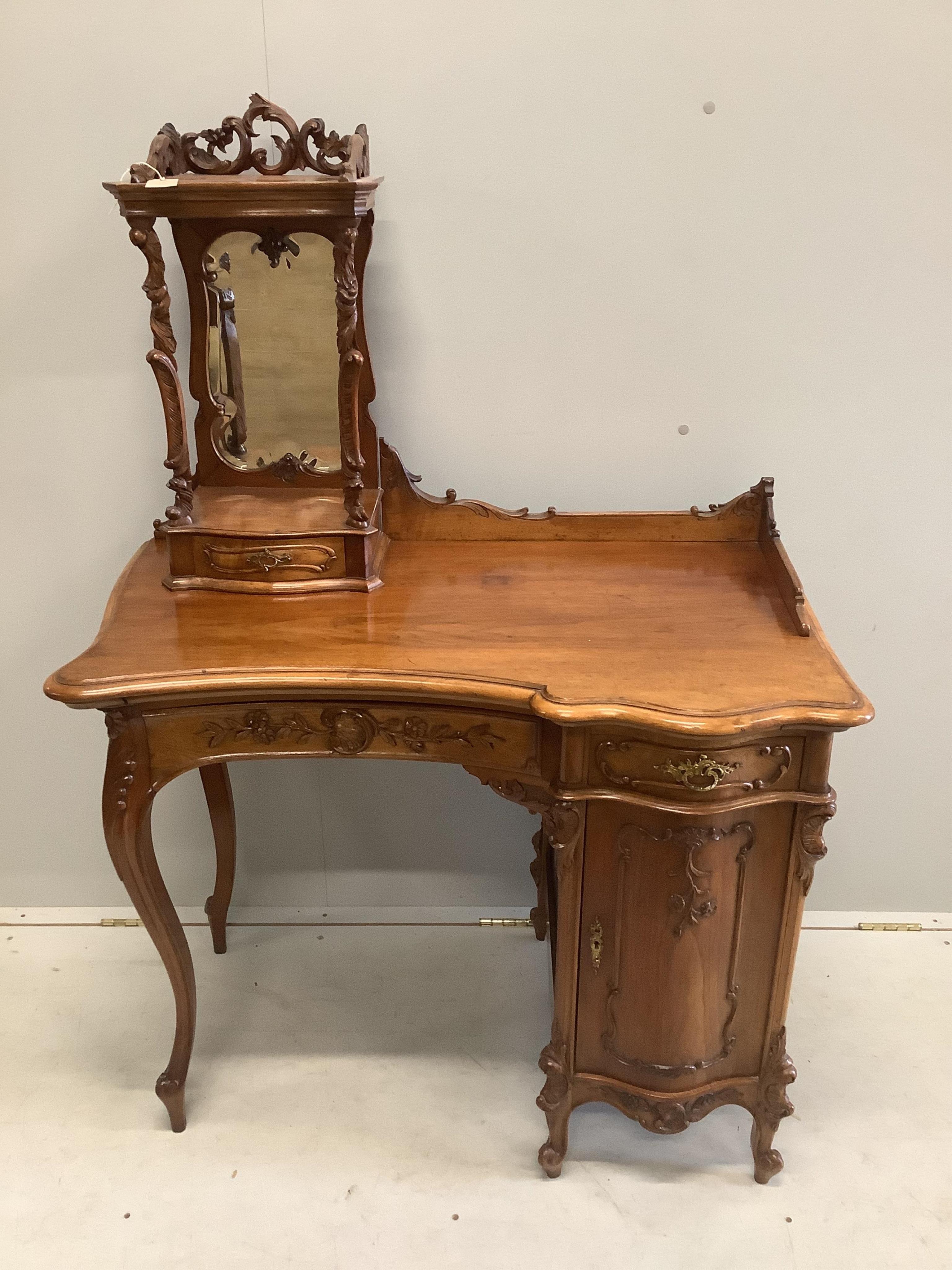 A Continental Art Nouveau carved walnut dressing table, width 92cm, depth 56cm, height 134cm. Condition - fair to good